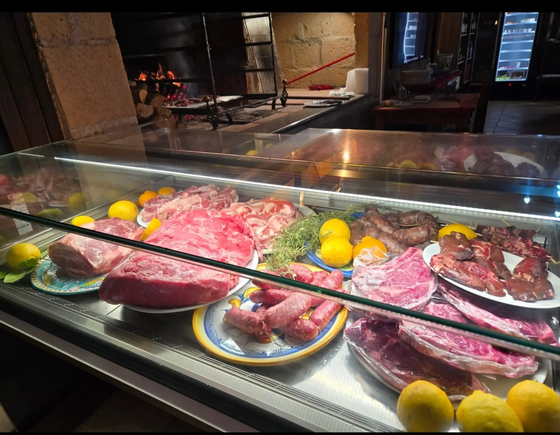 Vetrina refrigerata con tagli di carne fresca, salsicce e spiedini